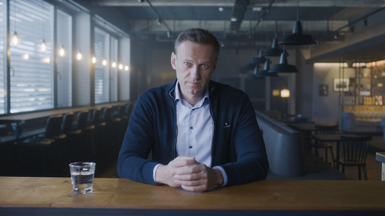 亚历克西·纳瓦尼（Alexei Navalny）的照片坐在桌子上，双手折叠