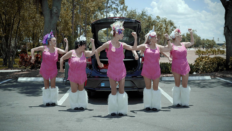 一群穿着粉色和白色服装的女人在外面跳舞