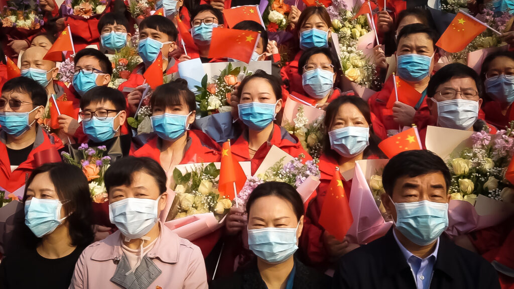 一群人都戴着面具，拿着鲜花。