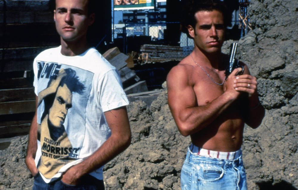 一名身穿白色莫里西t恤的男子和一名手持左轮手枪的赤膊男子肩并肩站在一起