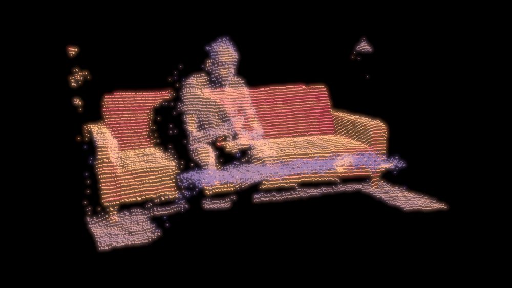 Man sitting on a sofa depicted in a somewhat abstract pattern of colored dots
