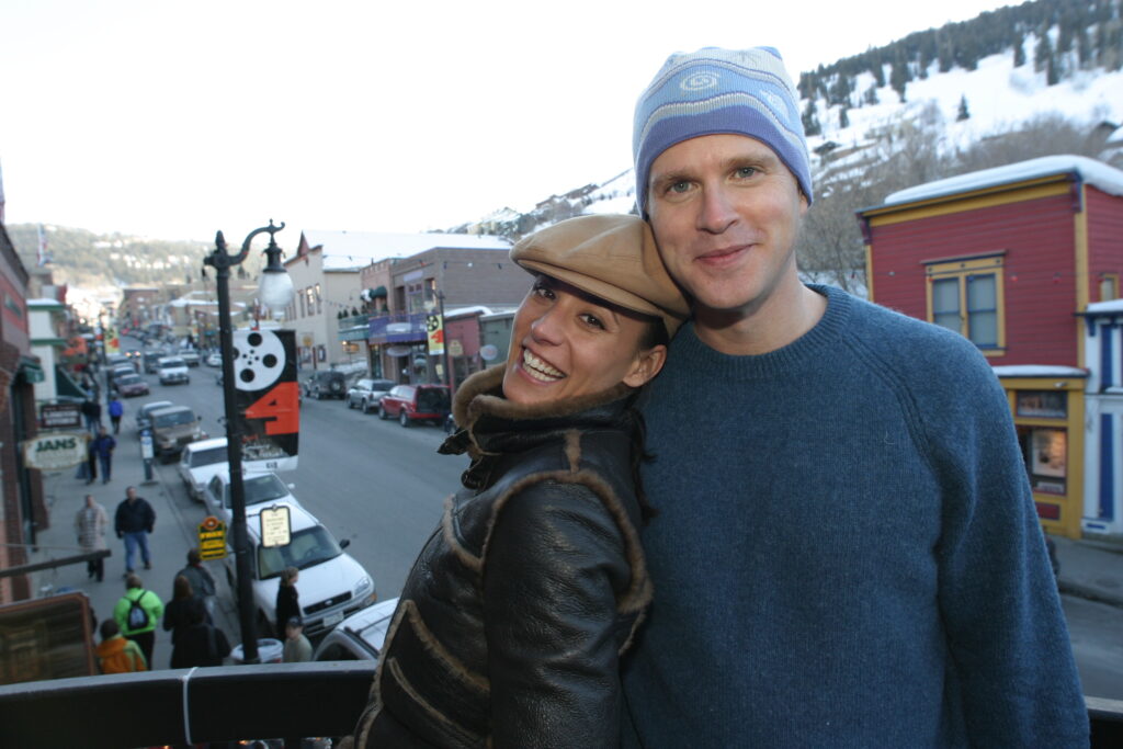 一个男人和一个女人在阳台上对着镜头微笑的主要街道在城市公园在圣丹斯电影节