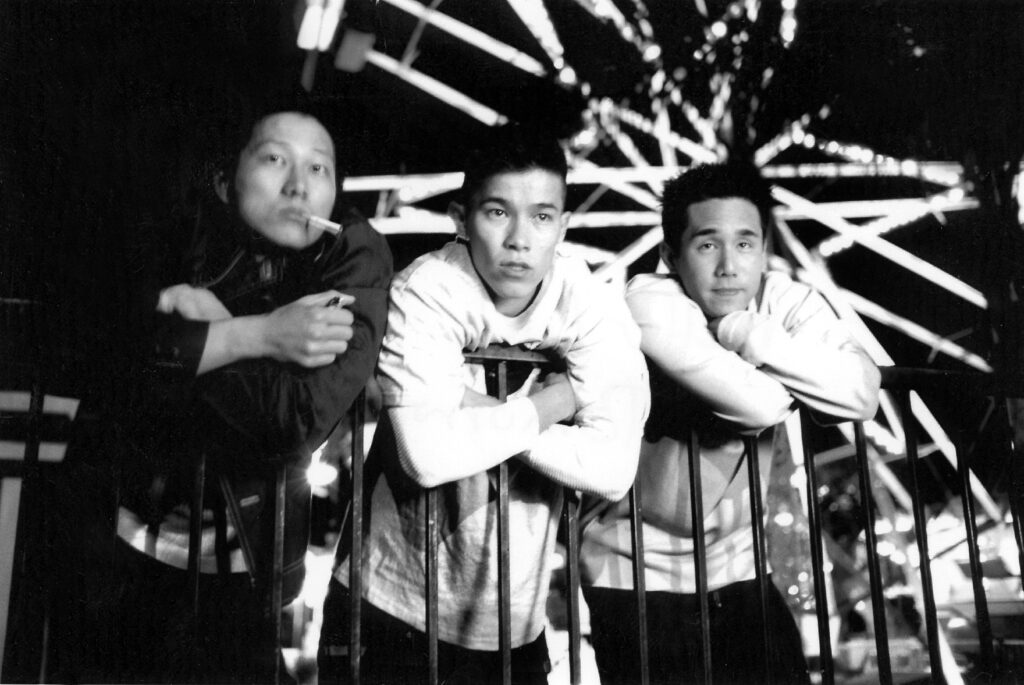 三名亚洲男子靠在栏杆上的摩天轮