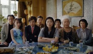 一个亚洲家庭坐落在一个表的相当精致的点心。没人显得特别高兴。